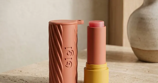 Terracotta fluted lip balm holder with a name up the side, next to a lip balm.